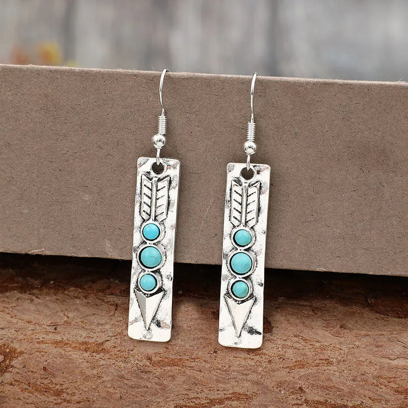 Silver geometric earrings with turquoise detail on white background