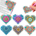 Set of six handmade PU leather flower cornerite bookmarks with stick-on crystals on a surface.