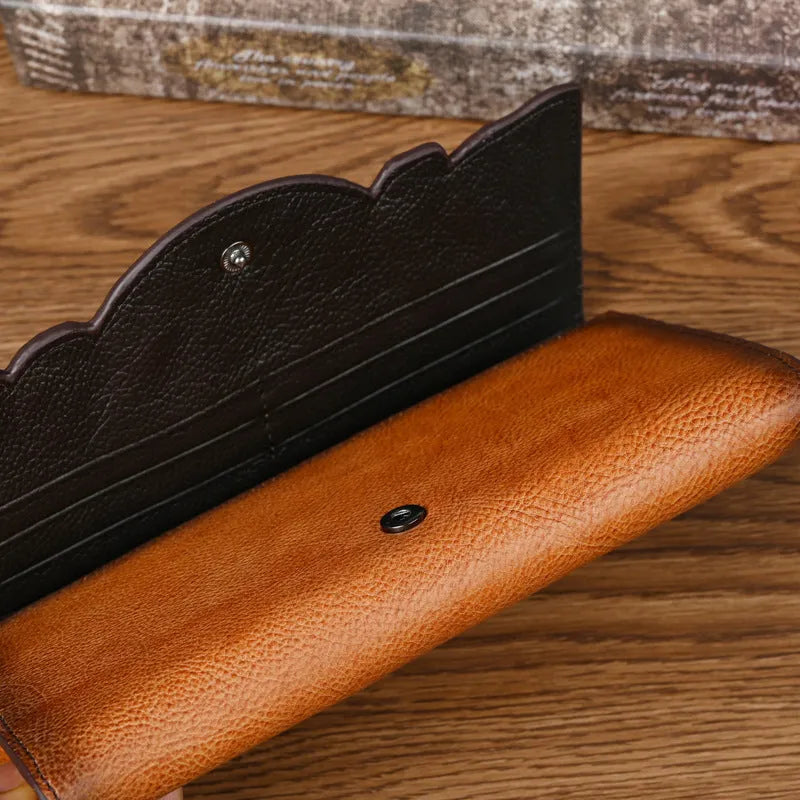 Women's brown tri-fold leather wallet with an embossed floral pattern, shown open to reveal compartments.