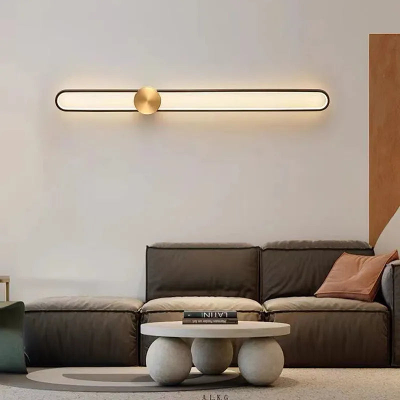 Round minimalist iron wall lamp with warm white LED light in black or gold finish.
