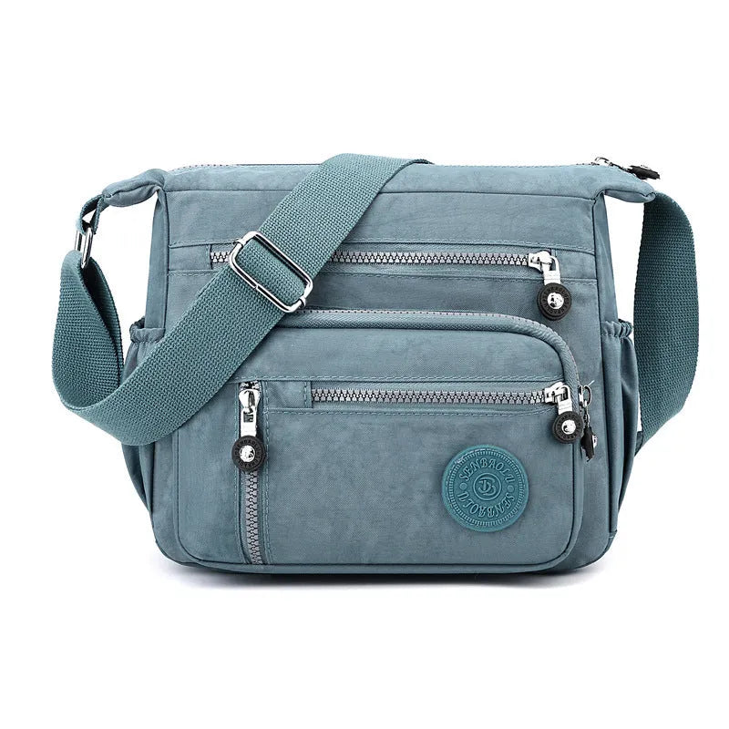Nylon messenger shoulder bag in square vertical shape shown in light blue colour.