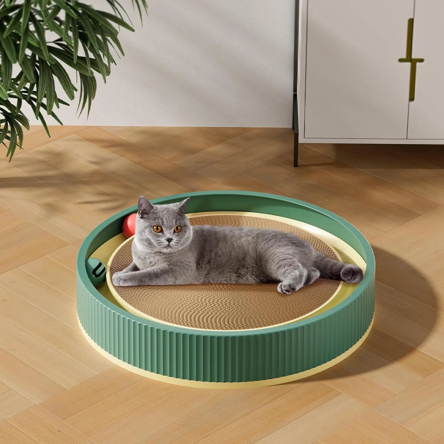 Large green circular cardboard cat scratching board with three built-in ball toys on a white base.