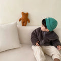 A child's blue sherpa fleece jacket with a full zip, high collar, and front pockets on a hanger.