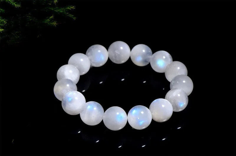 Natural white Moonstone round bead bracelet on a wrist, showing polished geometry beads.