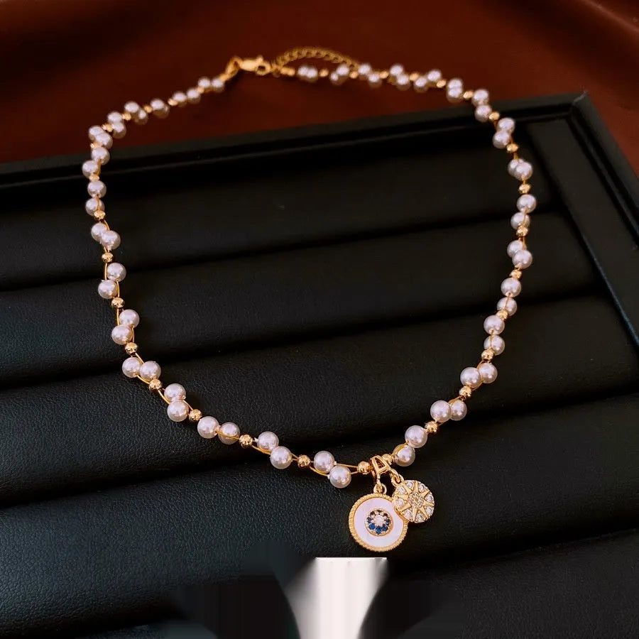 Gold electroplated necklace with round imitation pearl pendant and Chinese style geometric design
