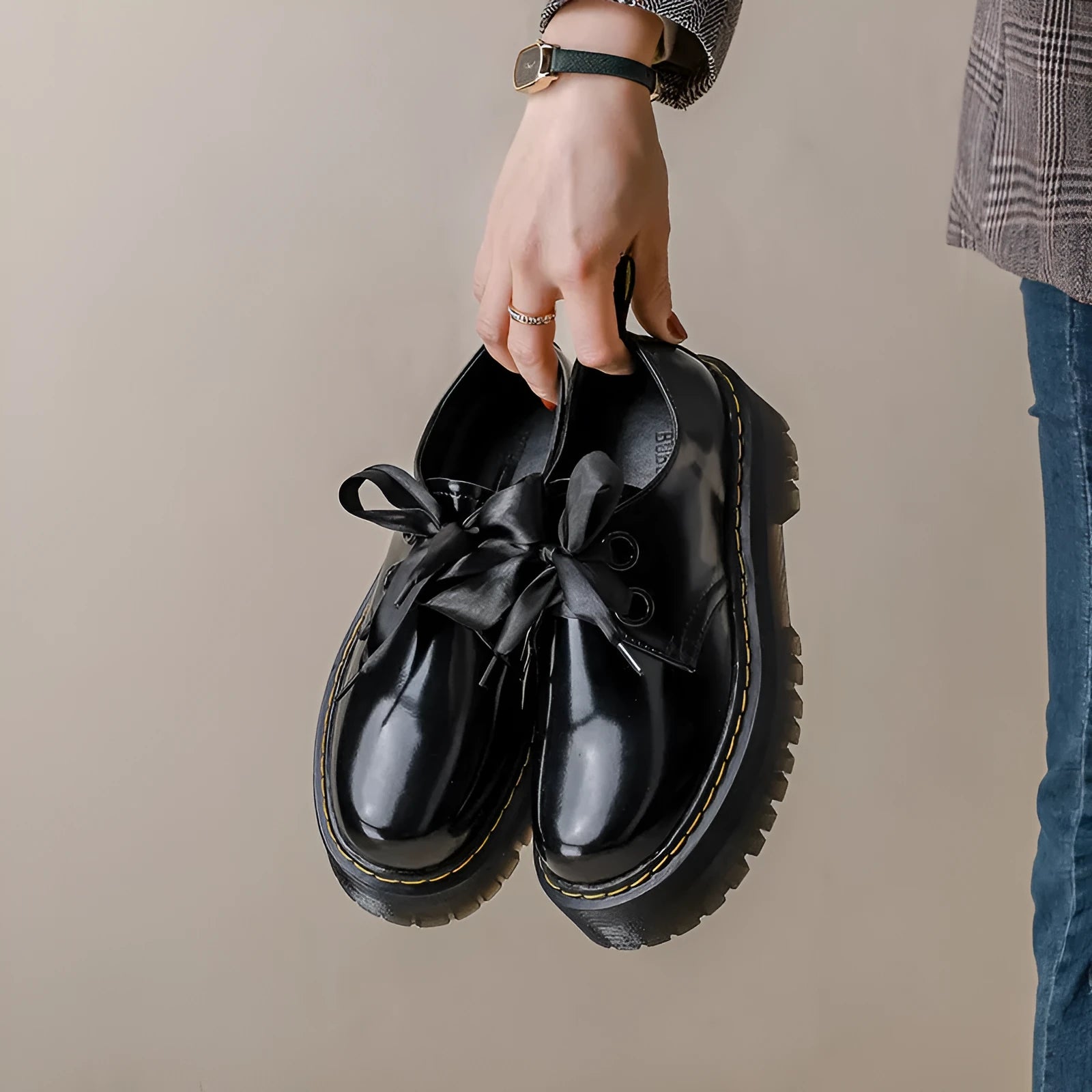 Black women's lace-up shoes with a thick sole, ribbon detail, and cross straps.