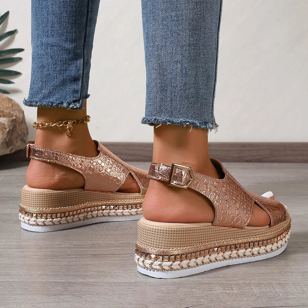 Gold women's Roman sandals with round hollow-out toe and an ankle buckle strap on a rubber sole.