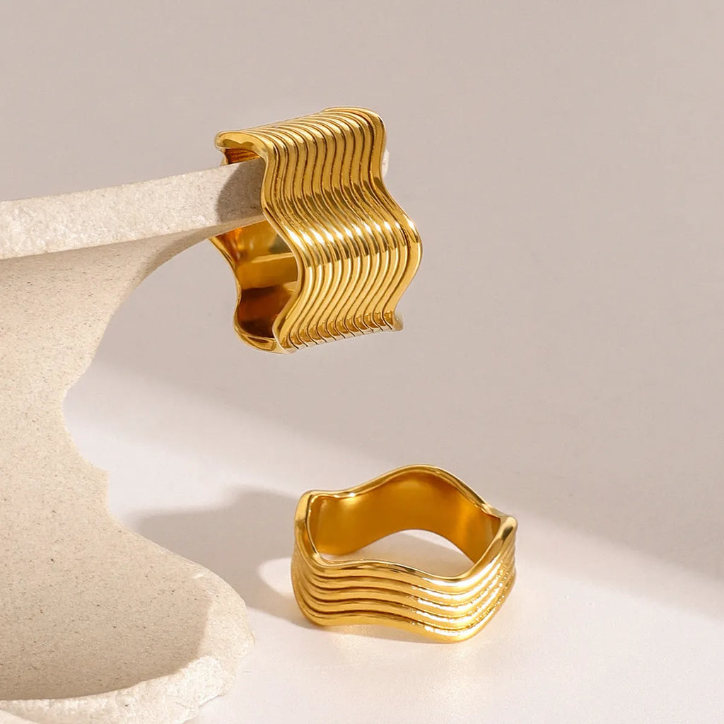 Stainless steel wide geometric wave ring with Korean style electroplated finish.