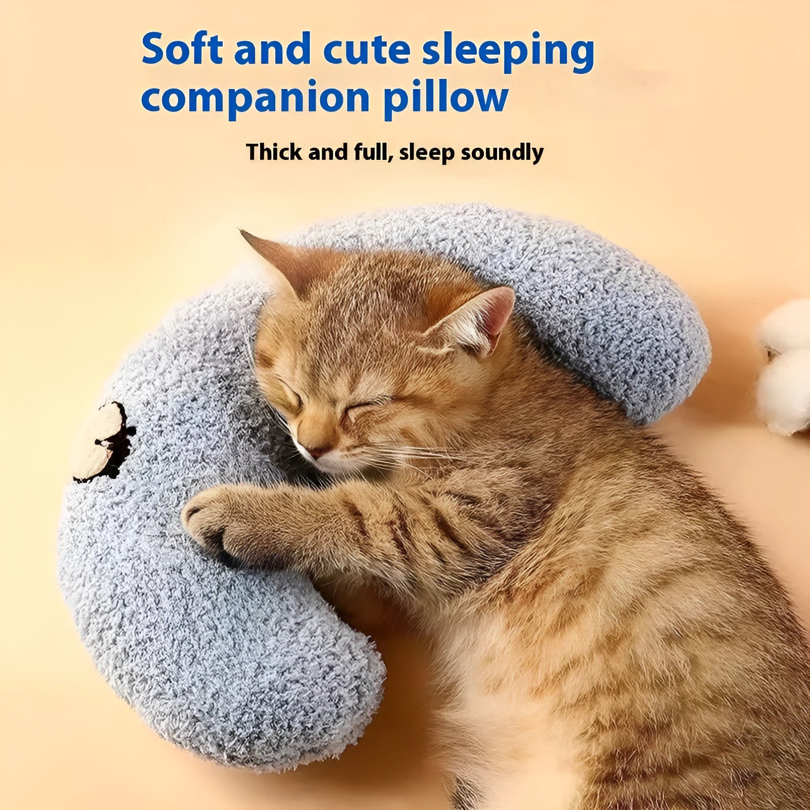 Blue U-shaped cat sleeping mat with integrated moon-shaped neck pillow on a wooden floor.