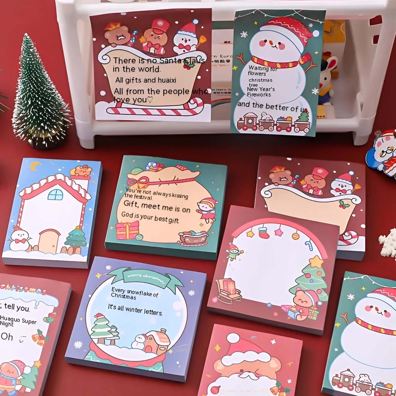 Christmas sticky notes book with festive designs of bear, elf, gift, house, sled, snowman, crystal ball, and Santa Claus.
