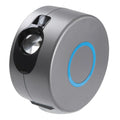 Grey starry sky projection lamp with remote control on a table, projecting colourful light dots on a dark wall.