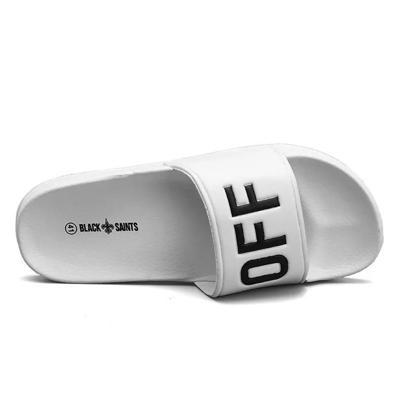 Men's large black and white open toe slippers with a rubber sole on a plain background.