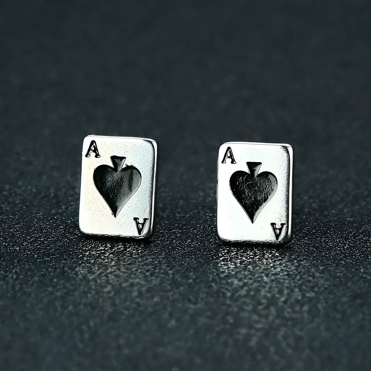 Small black peach A stud earrings in titanium steel with quadrilateral geometric punk style, shown as a pair.