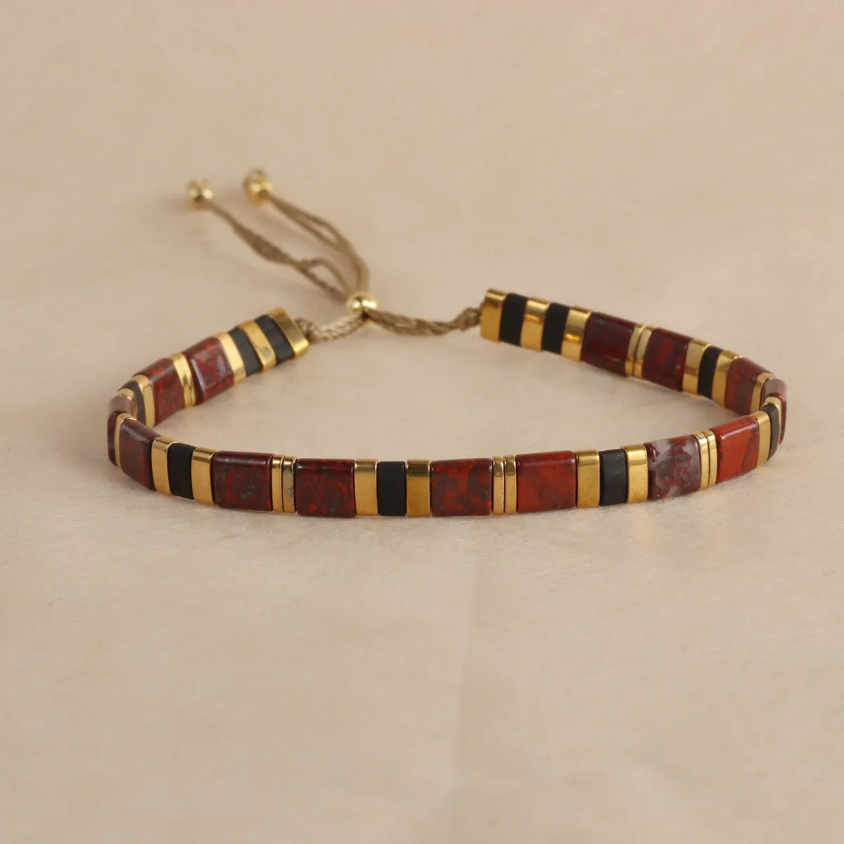 Geometric round glass bead bracelet in five colour options on a wrist.