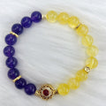 Handmade women's bracelet with yellow and purple amethyst crystals on wrist