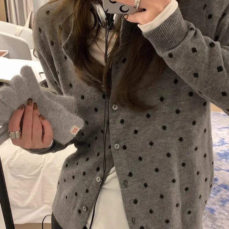 Women's grey loose-fit knitted cardigan with a crocheted flower on the front.