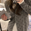 Women's grey loose-fit knitted cardigan with a crocheted flower on the front.