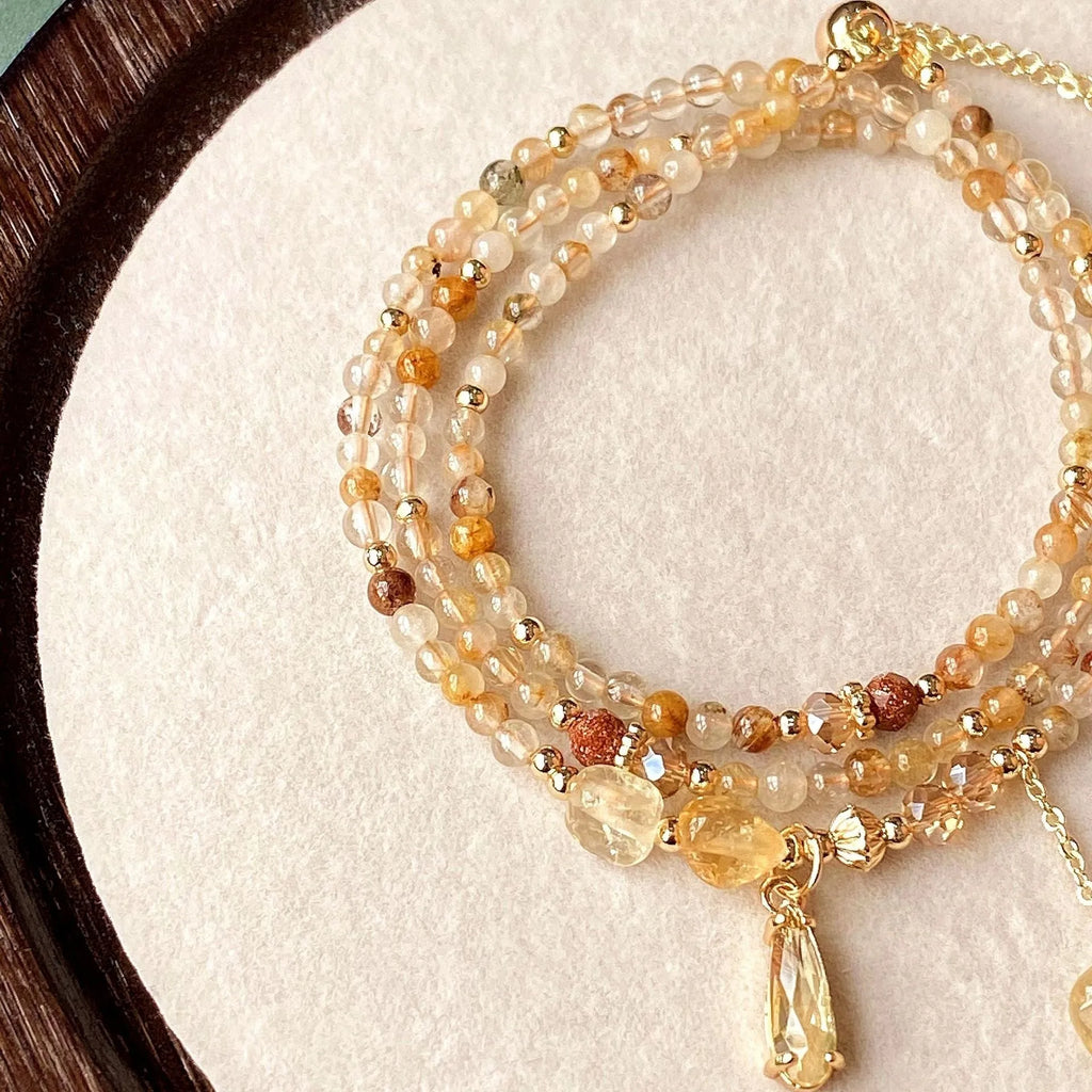 Gold tone women's bracelet with natural caramel coloured citrine crystal and Saturn decorative element