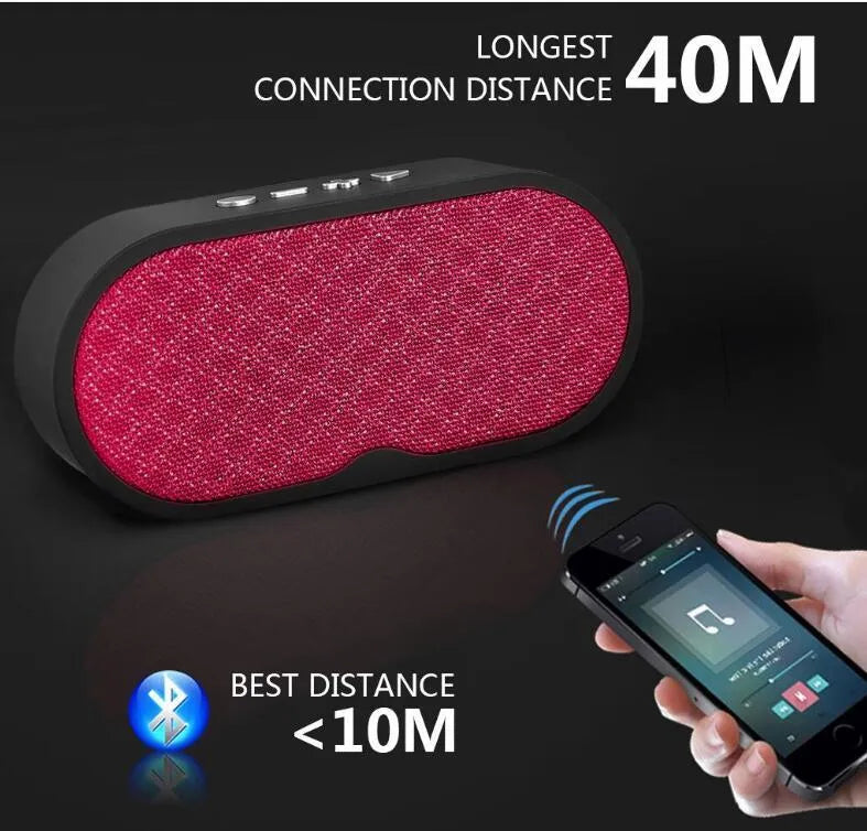 A grey Bluetooth wireless subwoofer speaker unit with a front-facing grille, sitting on a surface.