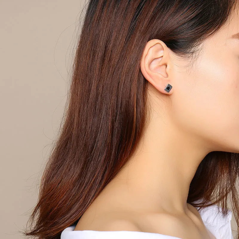 Small black peach A stud earrings in titanium steel with quadrilateral geometric punk style, shown as a pair.
