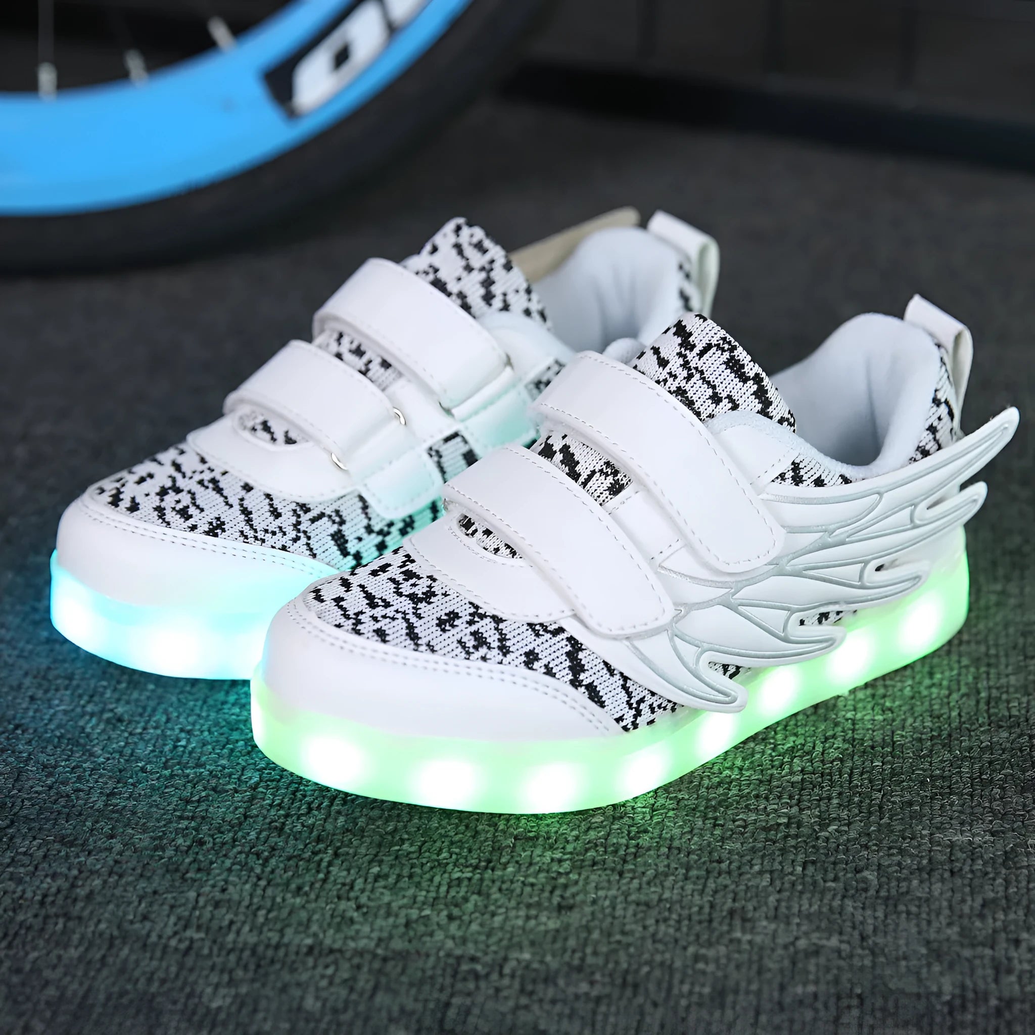 Children's plum red and white LED light-up sneakers showing USB charging port and colourful illumination.