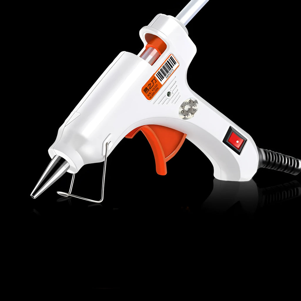 White electric hot glue gun with metal stand and glue sticks on a workbench.