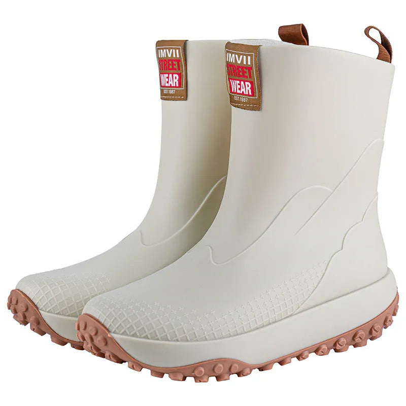 Men's black and red PVC rain boot with a round toe and non-slip plastic sole on a wet surface.