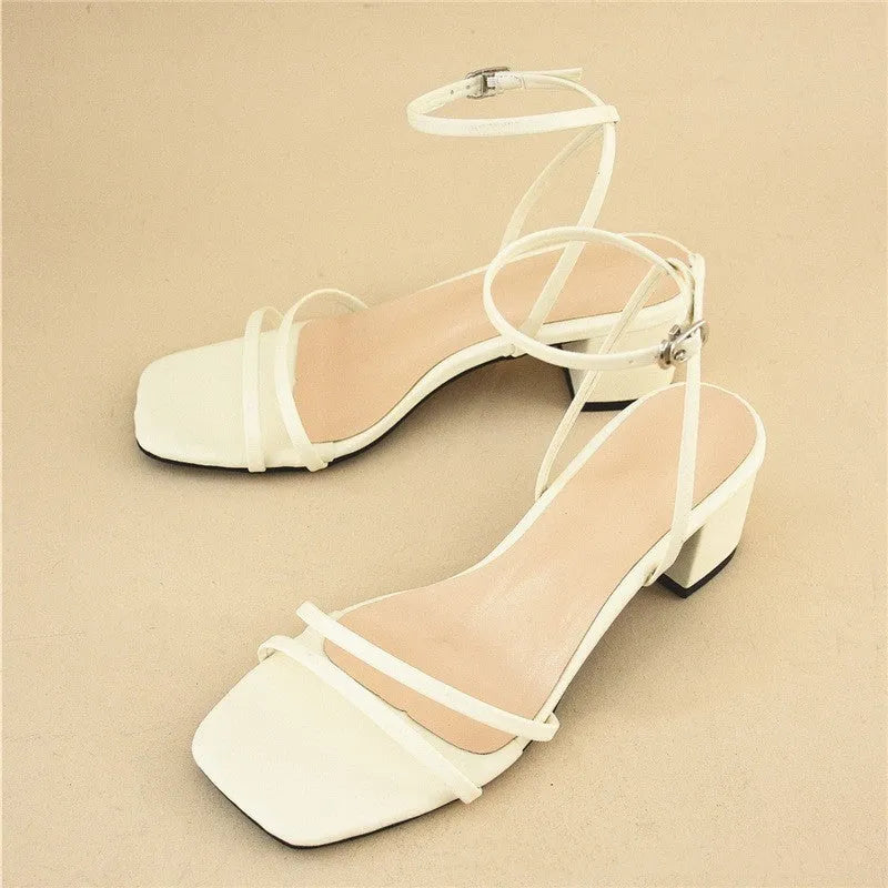 Beige women's stiletto sandals with a chunky heel, square toe, and an ankle buckle strap.
