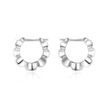 A pair of sterling silver geometric earrings with a round retro design.