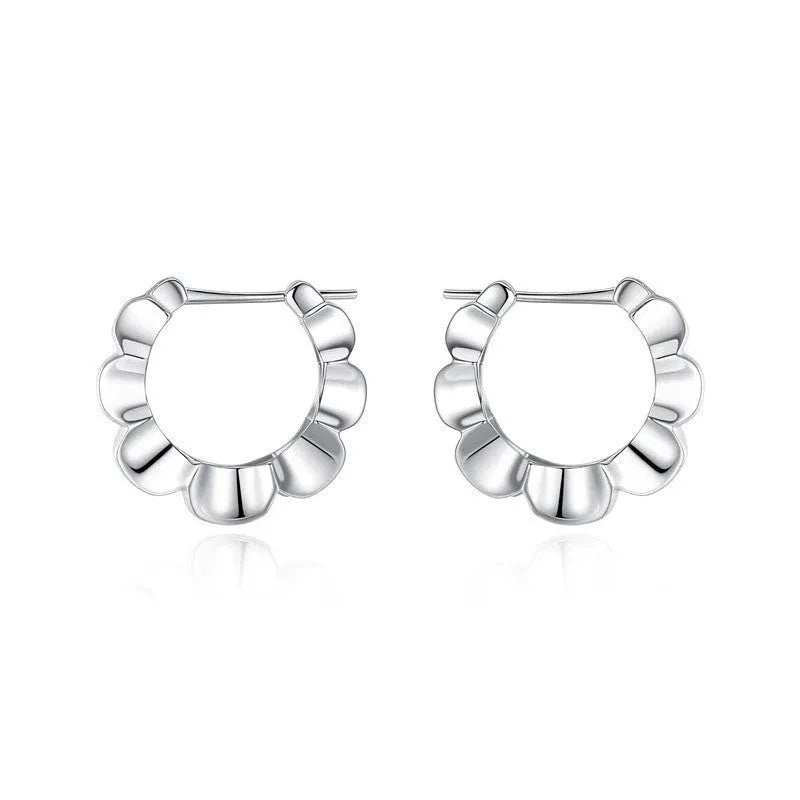 A pair of sterling silver geometric earrings with a round retro design.