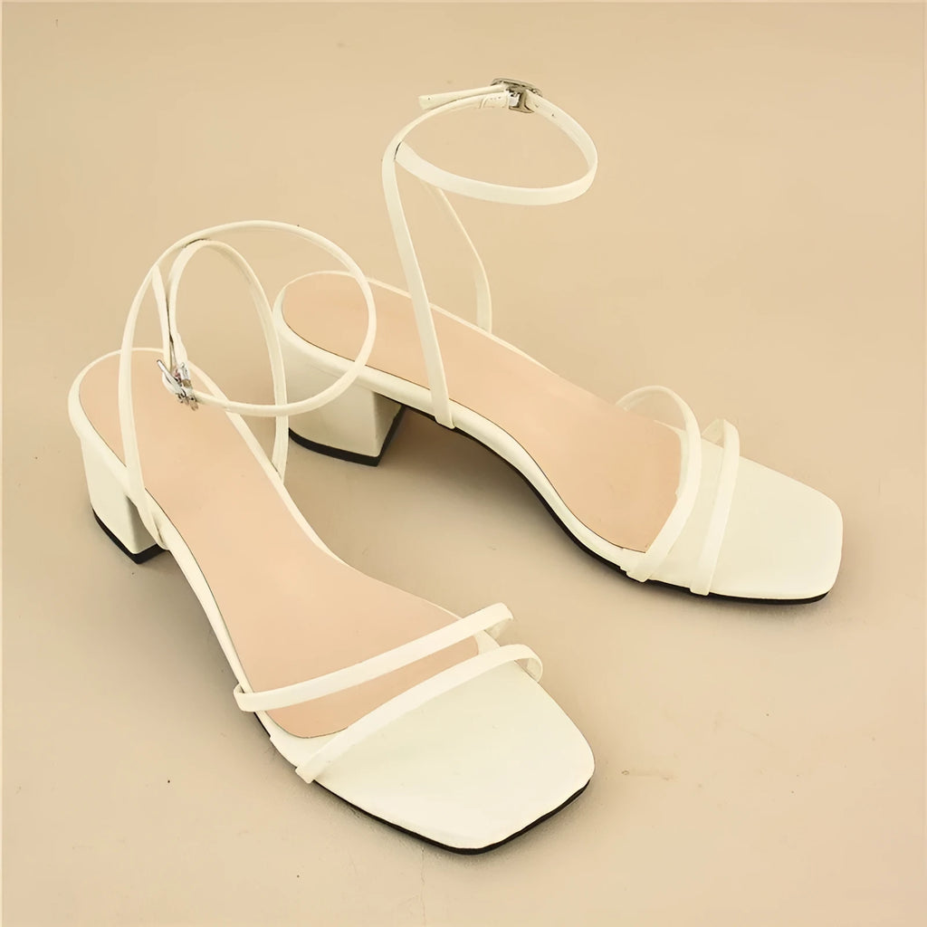 Beige women's stiletto sandals with a chunky heel, square toe, and an ankle buckle strap.