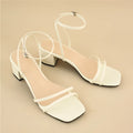 Beige women's stiletto sandals with a chunky heel, square toe, and an ankle buckle strap.