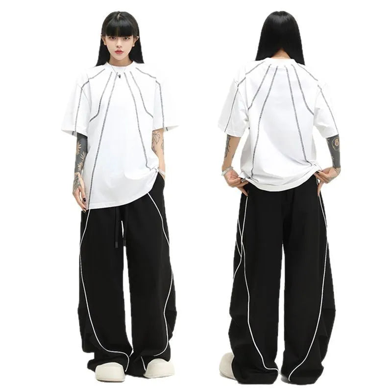 Black striped pleated wide-leg hip hop trousers laid flat, showing loose fit and mid waist.