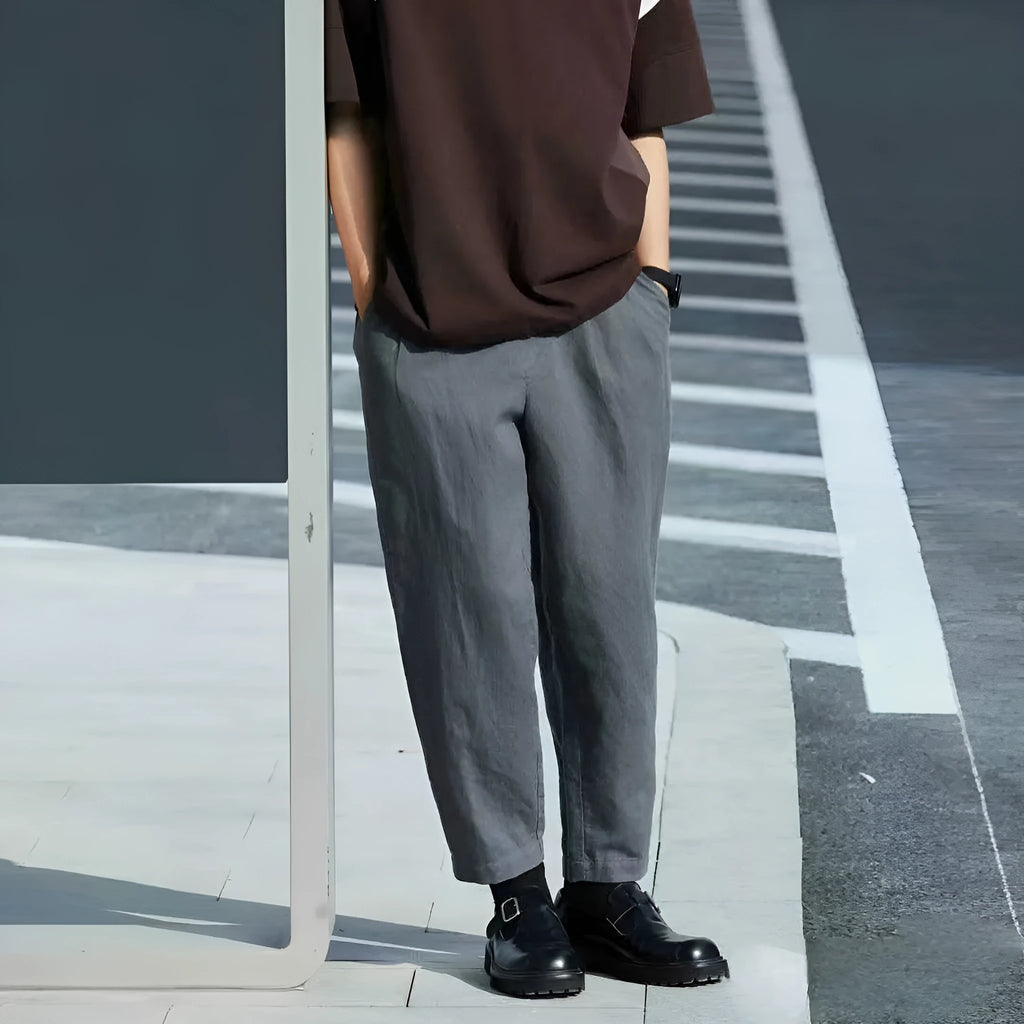 A man wearing beige loose straight-leg casual trousers with a drawstring waist.
