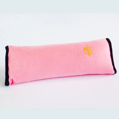 Children car pillow in grey micro-suede fabric attached to a car seat belt shoulder strap