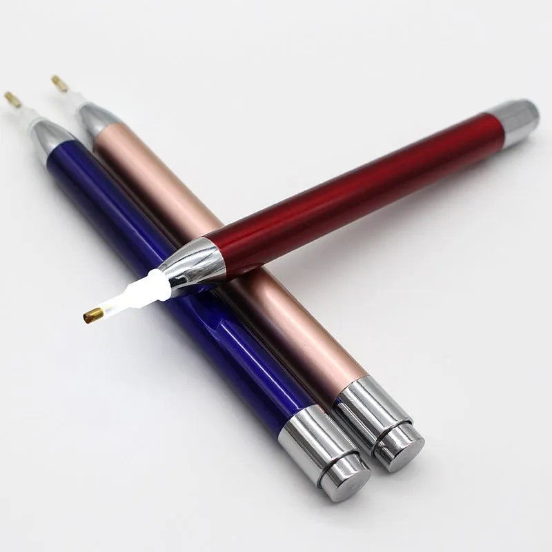 Blue luminous aluminium alloy drill pen for diamond painting and cross stitch crafts on a dark surface.