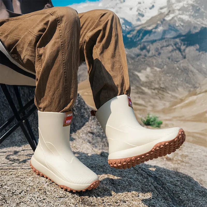 Men's black and red PVC rain boot with a round toe and non-slip plastic sole on a wet surface.