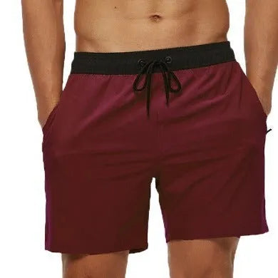 Men's blue stitching waist training shorts with zipper pockets and a drawstring, laid flat.