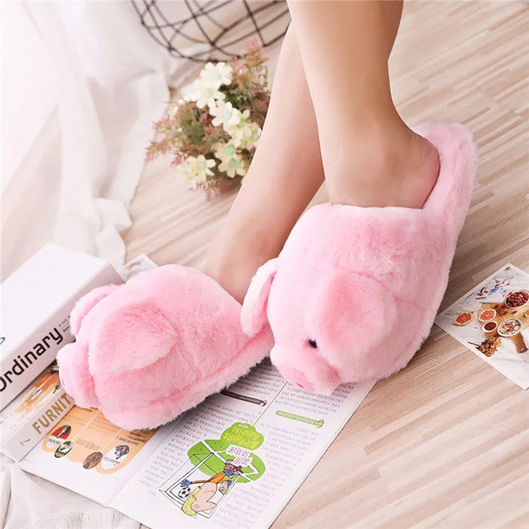 Pink pig-shaped plush indoor slippers with a cute animal face design, shown on a plain background.