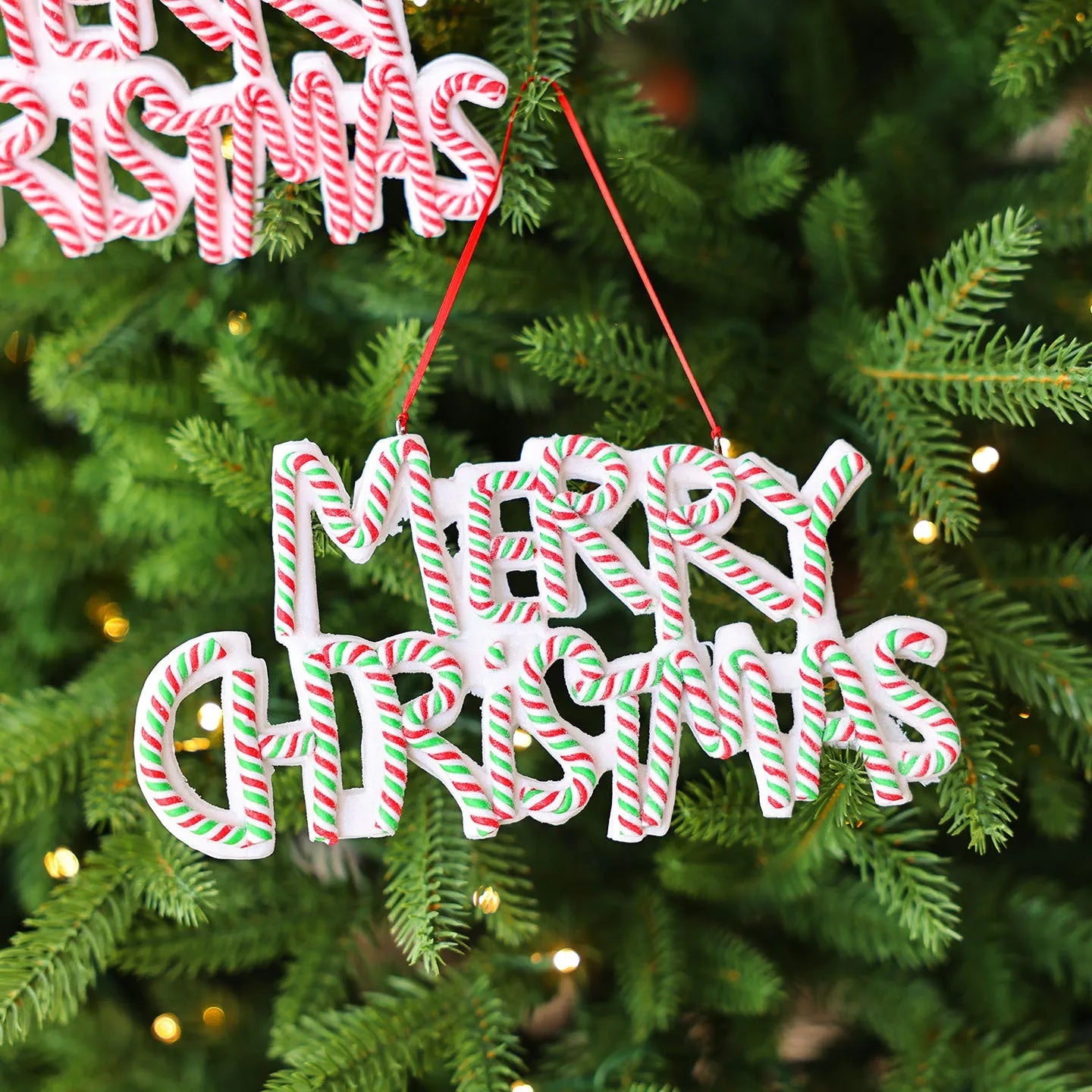 Merry Christmas letter plate polymer clay ornament in red and white hanging on Christmas tree branch