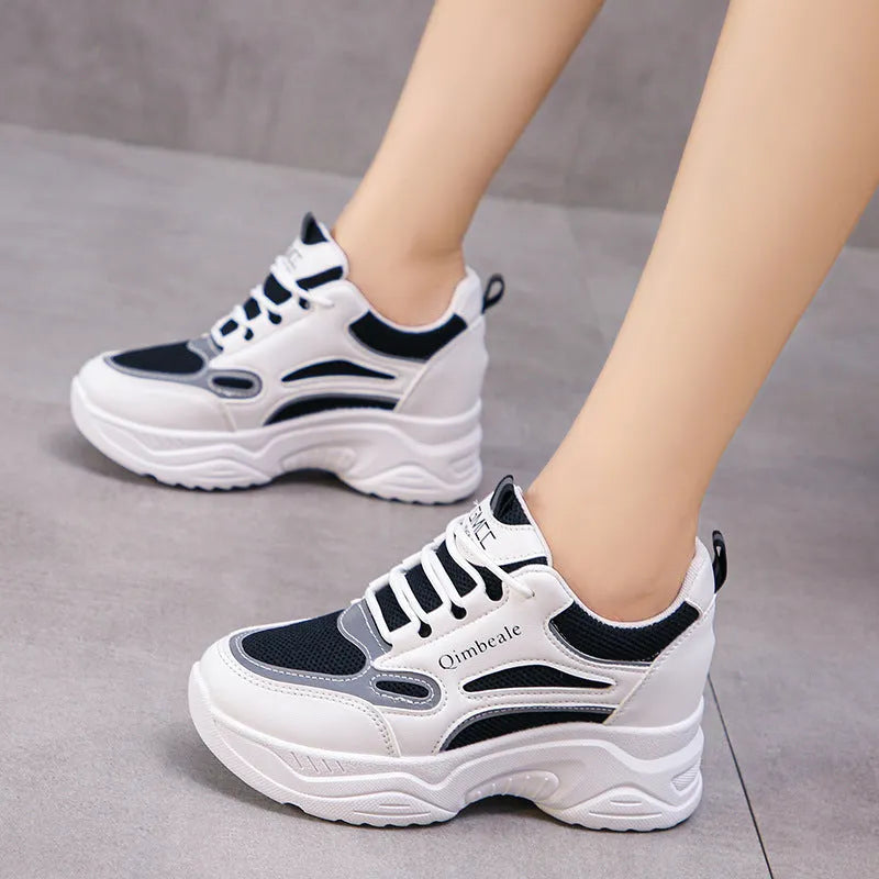 White height increasing dad shoes with mesh upper and wedge heel on a neutral background