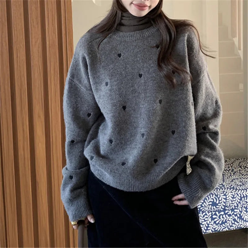 Women's loose cream embroidered acrylic pullover sweater with long sleeves, shown on a hanger.