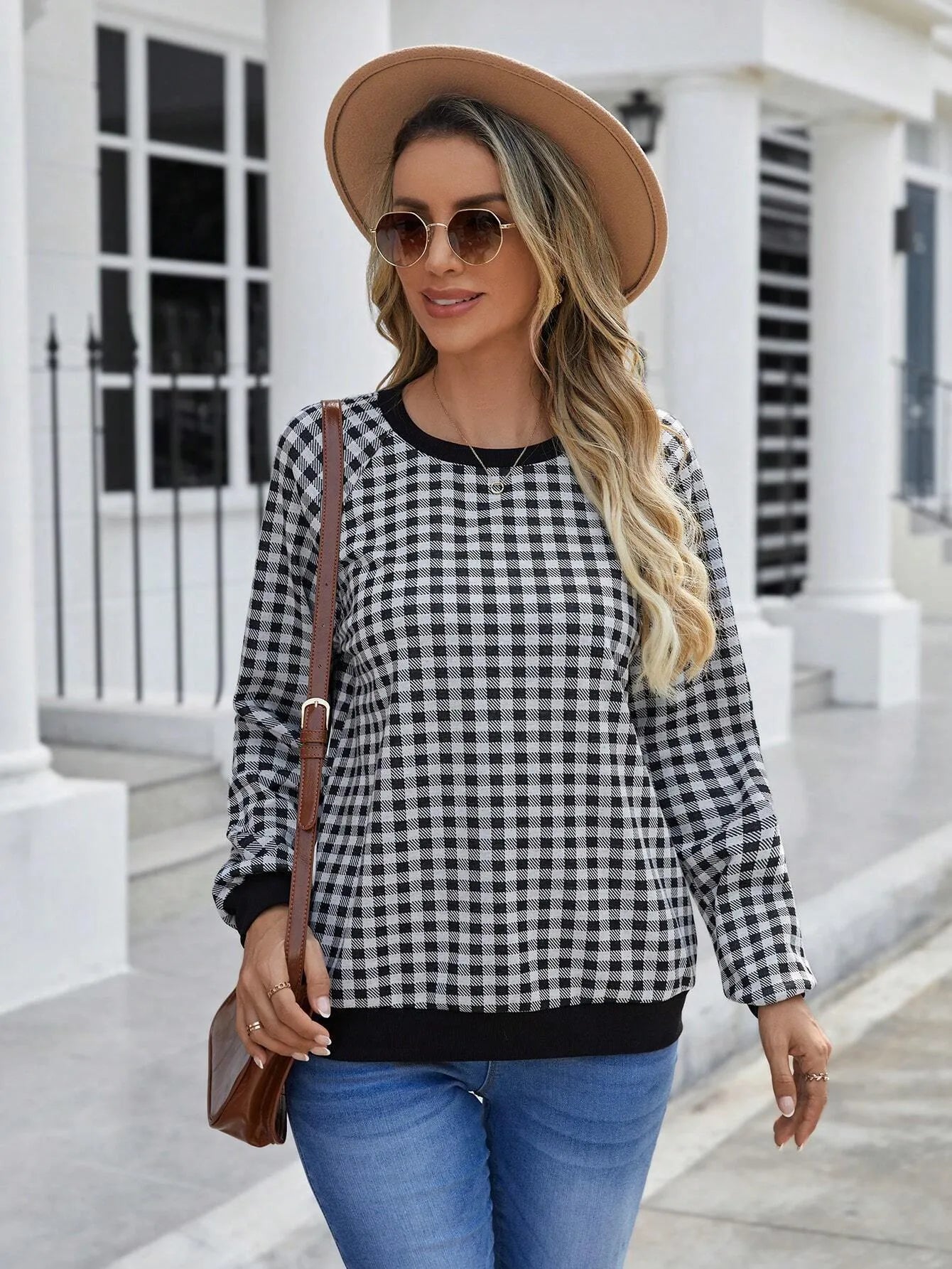 Black long sleeve polyester sweater with a plaid pattern, shown on a hanger.