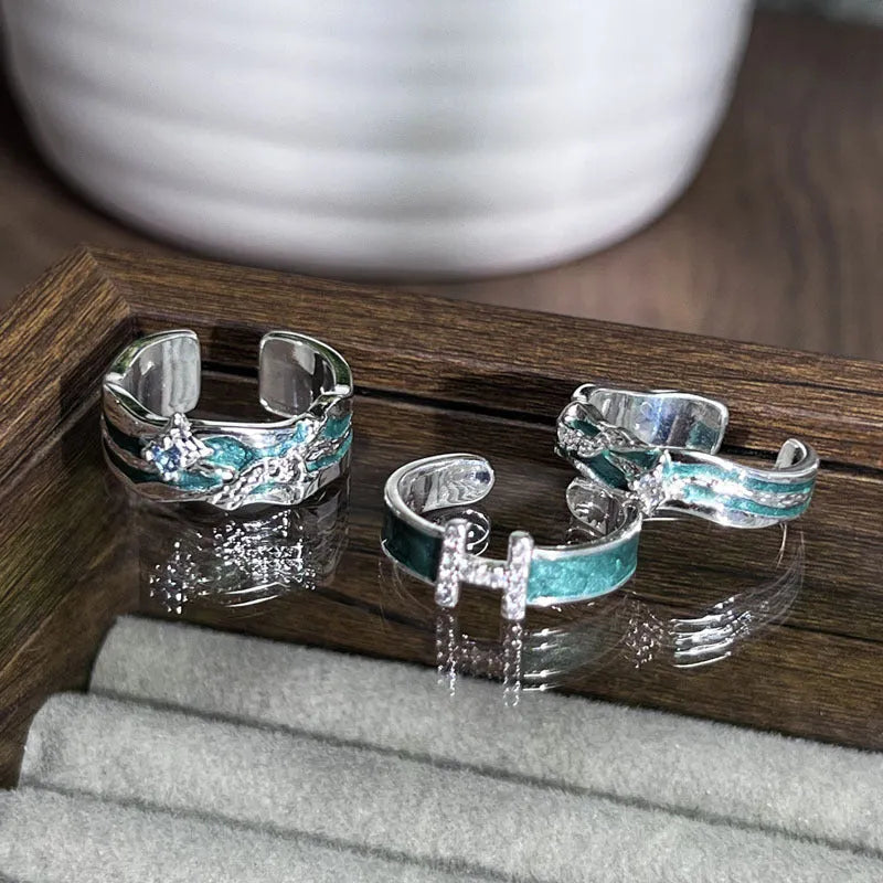 Mint green enamel ring with asymmetrical folded eight-point star design on copper band