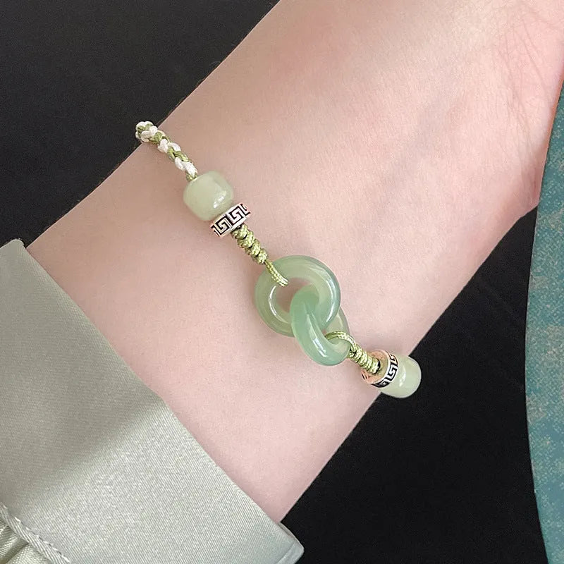 Green adjustable bracelet with jade peace buckle and copper zodiac charm.