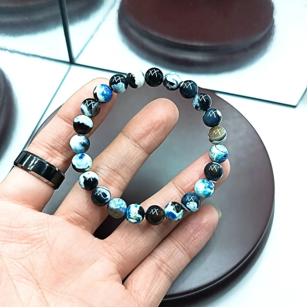 Close-up of a bohemian-style bracelet with 8mm natural agate beads and glass accents on a wrist.