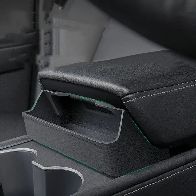 Black silicone sunglasses holder installed in Tesla centre console armrest compartment