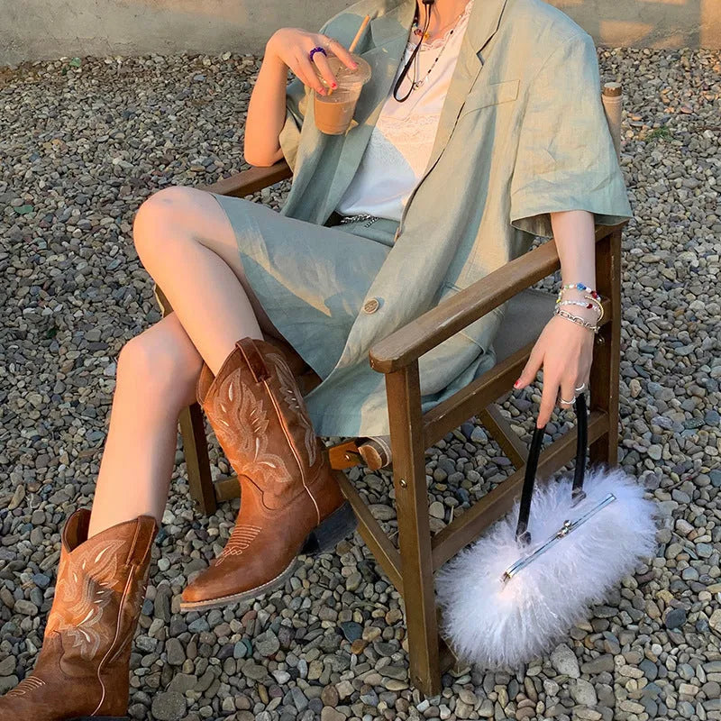 Brown embroidered women's mid-calf Martin boots with a square heel on a white background.
