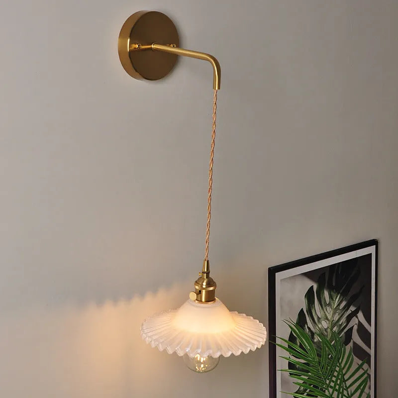 Retro copper wall lamp with a glass shade in a choice of six colours on a wall.