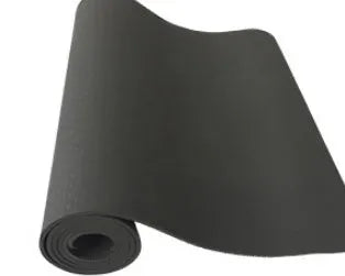 6mm TPE beginner yoga mat in black, rolled on wooden floor with textured non-slip surface visible